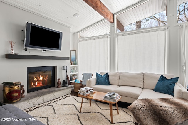 living room with a glass covered fireplace and beam ceiling