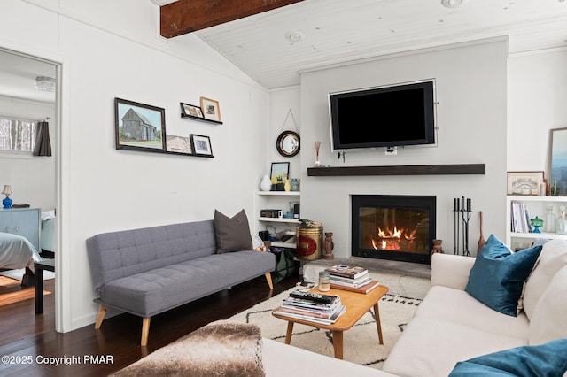 living room with lofted ceiling with beams, a glass covered fireplace, and wood finished floors