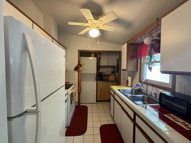 338 Tower Rd, Albrightsville, PA 18210 - kitchen with white appliances, a sink, stacked washing machine and dryer, tile counters, and light tile patterned floors