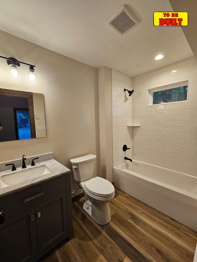 bathroom with visible vents, toilet, shower / bath combination, wood finished floors, and vanity