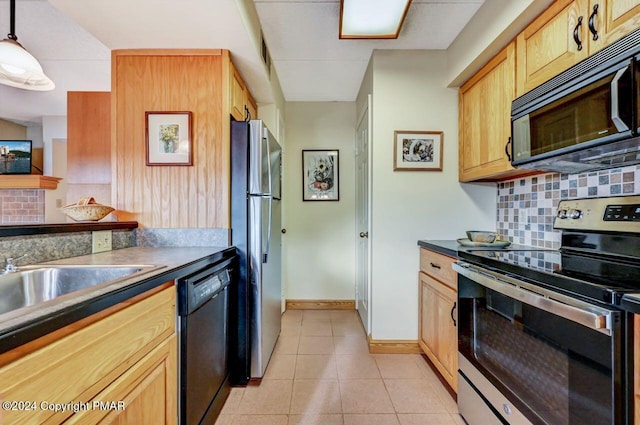 kitchen featuring light tile patterned floors, a sink, baseboards, decorative backsplash, and black appliances