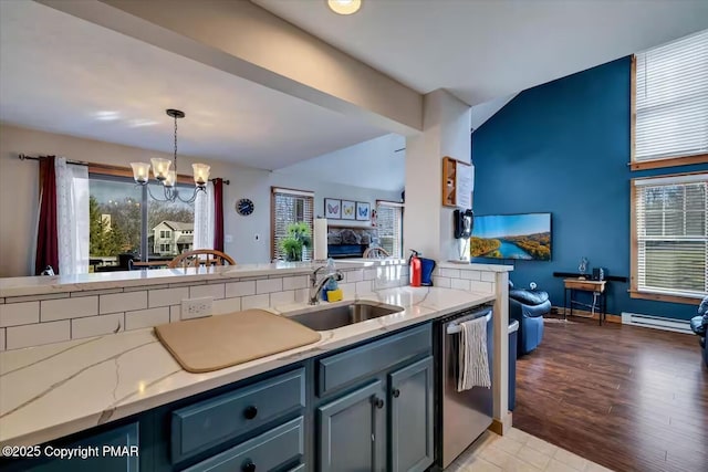 kitchen with a sink, a healthy amount of sunlight, baseboard heating, dishwasher, and an inviting chandelier