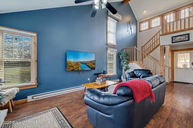 living area with an AC wall unit, a baseboard radiator, wood finished floors, and a wealth of natural light