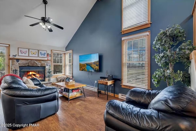 living area with high vaulted ceiling, a baseboard heating unit, a fireplace, wood finished floors, and a wealth of natural light