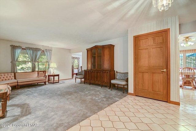 unfurnished room featuring a chandelier, light colored carpet, and baseboards