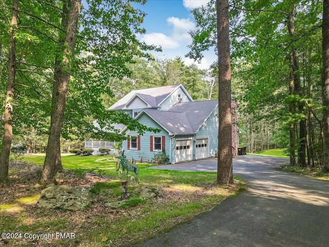 view of front of house featuring driveway, a front lawn, and an attached garage