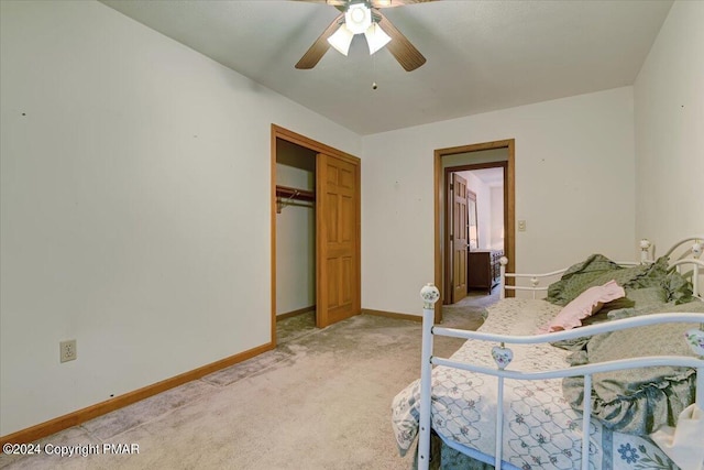 bedroom featuring a ceiling fan, a closet, light carpet, and baseboards