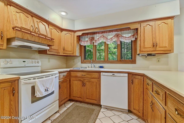 kitchen featuring white appliances, light countertops, a sink, and under cabinet range hood