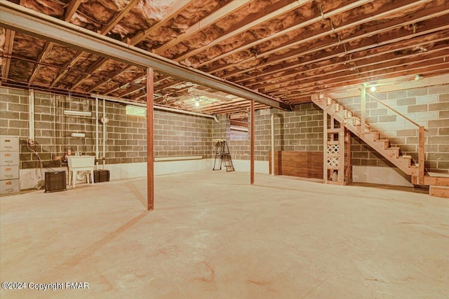 unfinished basement with stairway and a sink