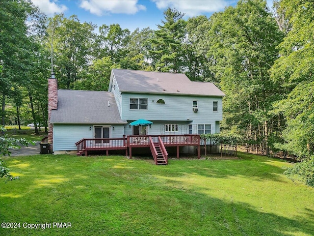 back of house featuring a deck, a yard, and a chimney