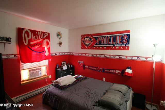 bedroom featuring hardwood / wood-style flooring, a baseboard radiator, and cooling unit