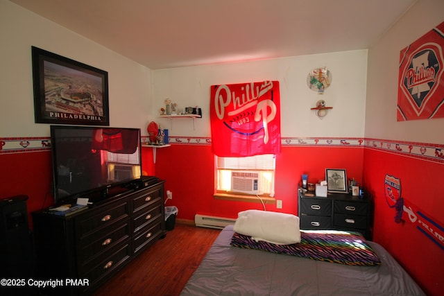 bedroom featuring cooling unit, hardwood / wood-style floors, and a baseboard heating unit