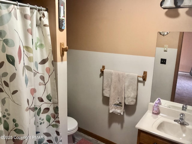 bathroom featuring toilet, vanity, and a shower with shower curtain