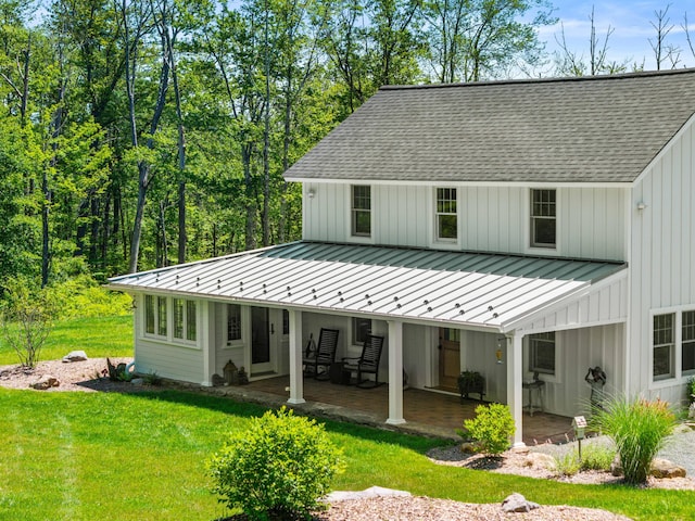 5126 Beattys Cir, Buck Hill Falls, PA 18323 - back of house with a standing seam roof, board and batten siding, roof with shingles, a yard, and a metal roof