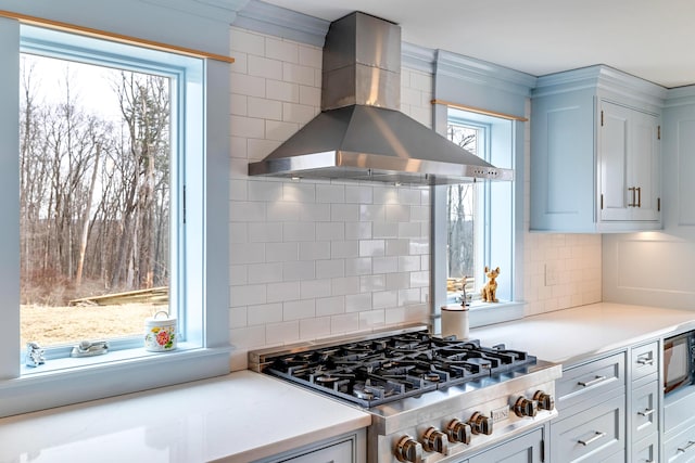 5126 Beattys Cir, Buck Hill Falls, PA 18323 - kitchen featuring wall chimney range hood, backsplash, stainless steel gas stovetop, and light countertops