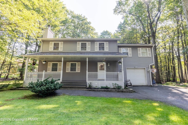 view of front facade with aphalt driveway, an attached garage, covered porch, a chimney, and a front yard