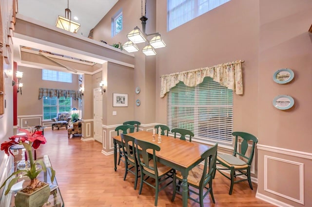 1218 Clymer Ln, Pocono Pines, PA 18350 - dining area with a high ceiling, a decorative wall, a wainscoted wall, and light wood-style flooring