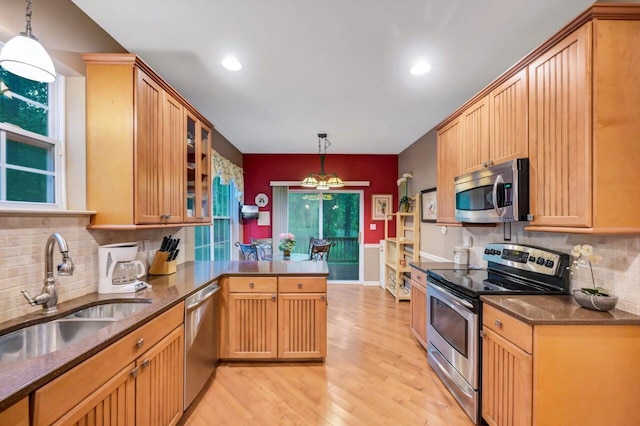 1218 Clymer Ln, Pocono Pines, PA 18350 - kitchen with stainless steel appliances, a peninsula, light wood finished floors, backsplash, and healthy amount of natural light