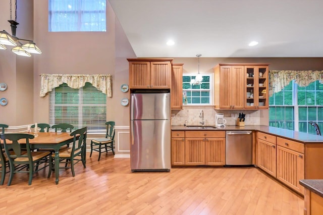 1218 Clymer Ln, Pocono Pines, PA 18350 - kitchen with stainless steel appliances, light wood finished floors, decorative backsplash, glass insert cabinets, and hanging light fixtures