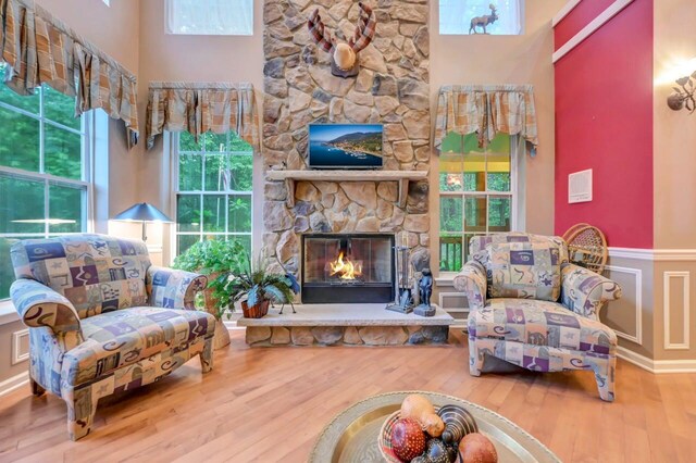 1218 Clymer Ln, Pocono Pines, PA 18350 - living area with a towering ceiling, wood finished floors, a fireplace, and wainscoting