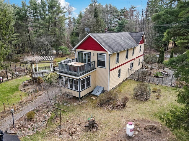 exterior space with fence, a balcony, roof with shingles, and a deck