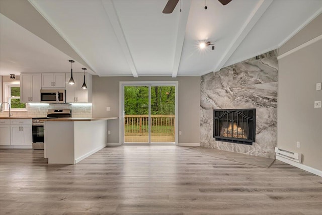 7 Eagle Ct, Lake Ariel, PA 18436 - unfurnished living room with a baseboard heating unit, a ceiling fan, a fireplace, and light wood-style floors