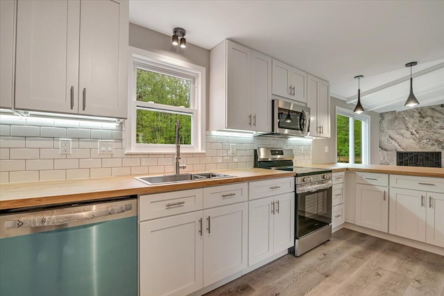 7 Eagle Ct, Lake Ariel, PA 18436 - kitchen featuring stainless steel appliances, wood counters, a sink, decorative backsplash, and light wood-type flooring