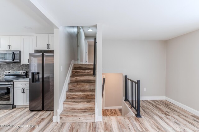 3011 Minqua Cir, Tobyhanna, PA 18466 - kitchen featuring appliances with stainless steel finishes, light wood-style flooring, white cabinets, light countertops, and baseboards