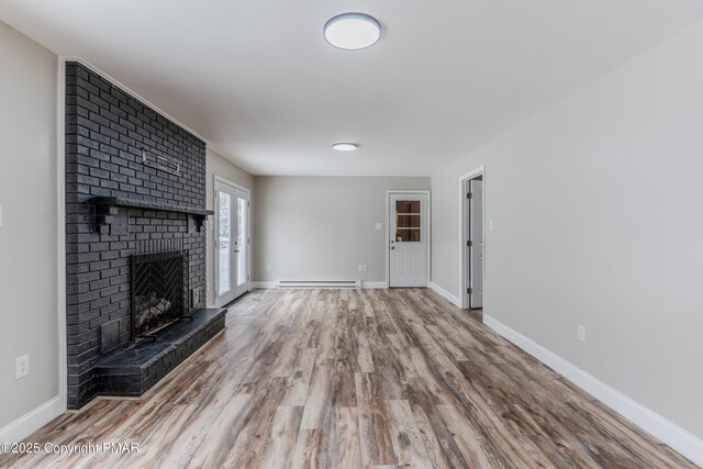 3011 Minqua Cir, Tobyhanna, PA 18466 - unfurnished living room featuring a fireplace, wood finished floors, baseboards, and a baseboard heating unit