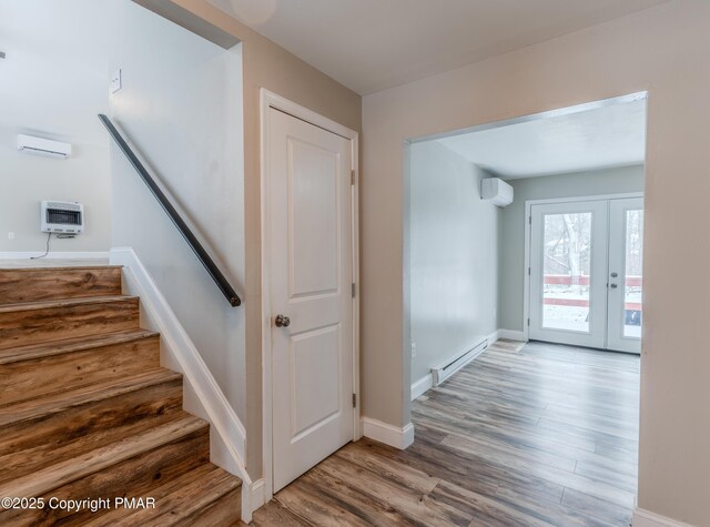 3011 Minqua Cir, Tobyhanna, PA 18466 - staircase with an AC wall unit, heating unit, wood finished floors, a baseboard radiator, and baseboards