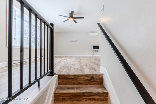 stairway featuring heating unit, an AC wall unit, hardwood / wood-style floors, and ceiling fan