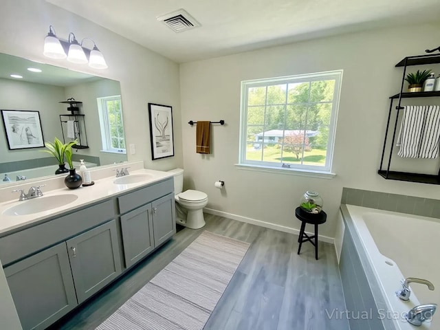 130 Sugar Hill Rd, Saylorsburg, PA 18353 - full bath with double vanity, wood finished floors, a garden tub, toilet, and baseboards