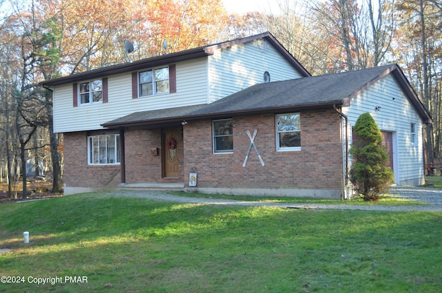 view of front of property featuring a shingled roof, brick siding, an attached garage, and a front lawn