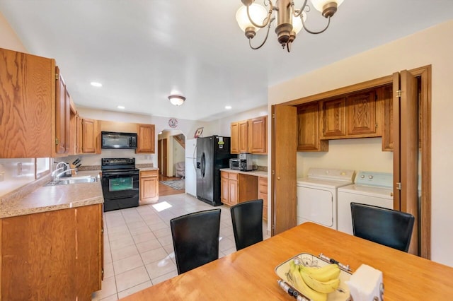 295 Wyomissing Dr, Pocono Lake, PA 18347 - kitchen with black appliances, washer and clothes dryer, light tile patterned floors, a chandelier, and light countertops