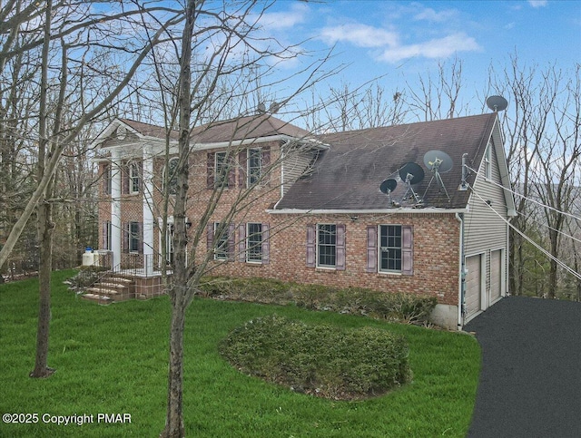 view of side of property featuring a garage and a yard