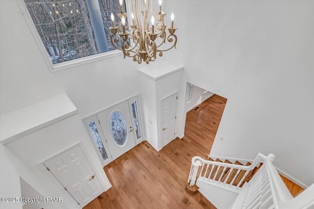 foyer featuring an inviting chandelier, hardwood / wood-style floors, and a high ceiling