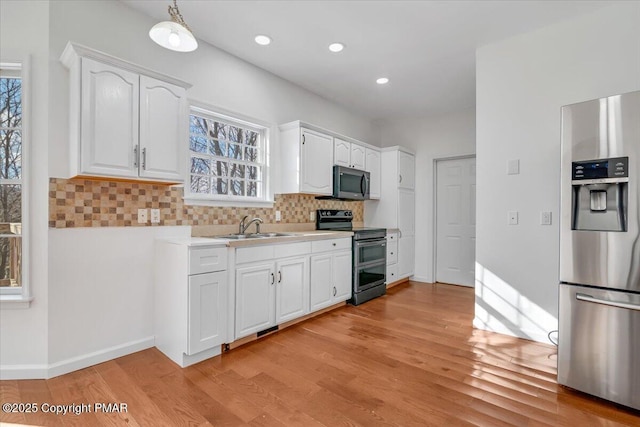 kitchen featuring appliances with stainless steel finishes, sink, decorative backsplash, and white cabinets