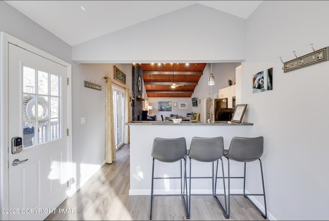 3126 Snowden Dr, Bushkill, PA 18324 - kitchen featuring light wood finished floors, a kitchen breakfast bar, a peninsula, wood ceiling, and freestanding refrigerator