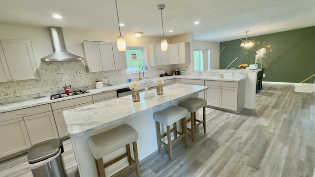 2292 Bismark Rd, Blakeslee, PA 18610 - kitchen featuring wall chimney range hood, a peninsula, backsplash, light wood finished floors, and recessed lighting