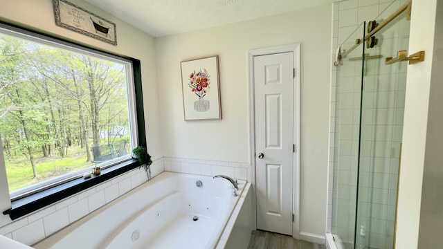 2292 Bismark Rd, Blakeslee, PA 18610 - bathroom featuring healthy amount of natural light, a tub with jets, a shower stall, wood finished floors, and a textured ceiling