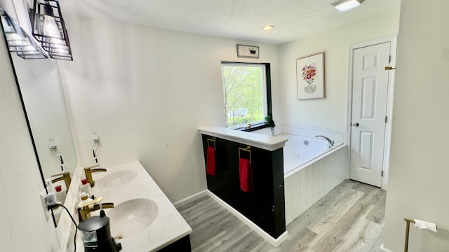 2292 Bismark Rd, Blakeslee, PA 18610 - full bathroom with wood finished floors, a bath, double vanity, and a textured ceiling