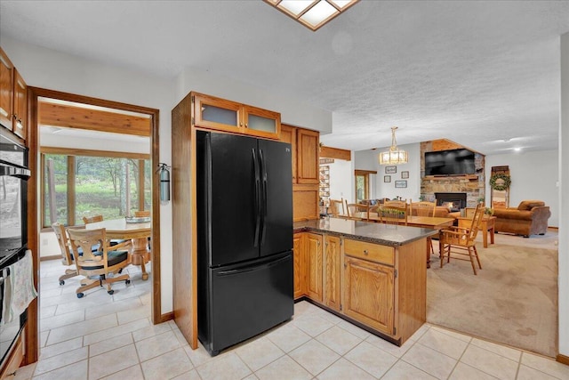 96 Wolf Hollow Rd, Lake Harmony, PA 18624 - kitchen with freestanding refrigerator, a fireplace, a peninsula, light tile patterned flooring, and open floor plan