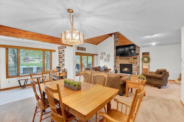 96 Wolf Hollow Rd, Lake Harmony, PA 18624 - dining space featuring a stone fireplace, baseboards, vaulted ceiling, healthy amount of natural light, and a chandelier