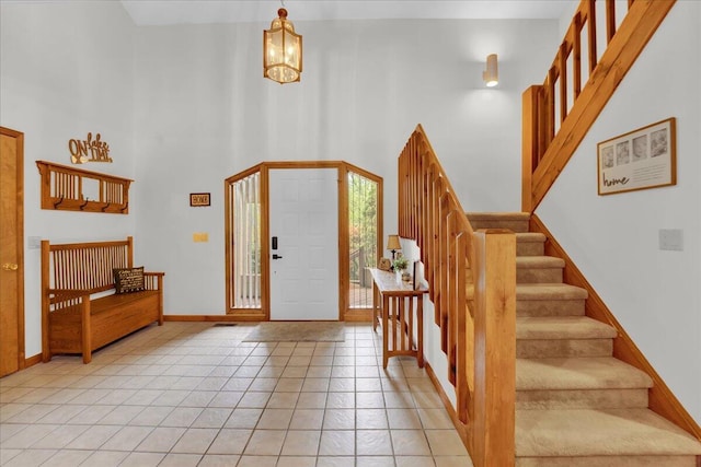 96 Wolf Hollow Rd, Lake Harmony, PA 18624 - foyer featuring stairs, a high ceiling, baseboards, light tile patterned floors, and a chandelier
