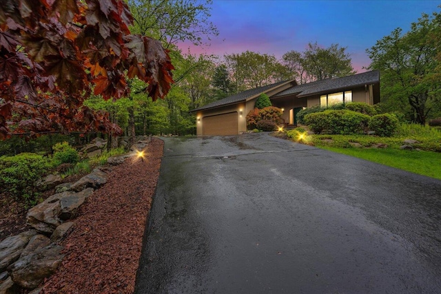 96 Wolf Hollow Rd, Lake Harmony, PA 18624 - view of front of house featuring asphalt driveway, an attached garage, and stucco siding