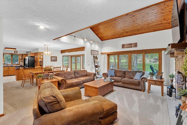 96 Wolf Hollow Rd, Lake Harmony, PA 18624 - living area featuring light colored carpet, a chandelier, a fireplace, a textured ceiling, and high vaulted ceiling