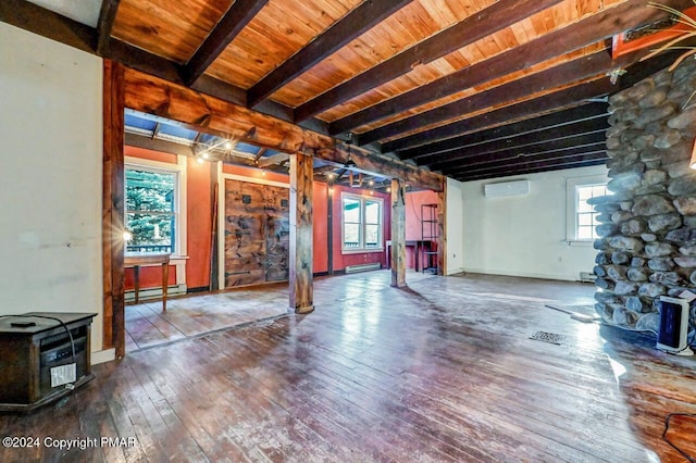 below grade area featuring a wood stove, wood-type flooring, a baseboard heating unit, and a wall mounted AC