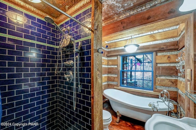 bathroom with a soaking tub, a shower stall, and toilet