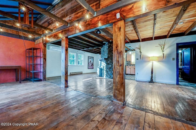 basement featuring a baseboard radiator, wood-type flooring, and baseboards