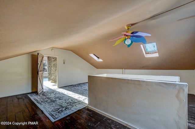 additional living space featuring lofted ceiling with skylight, wood-type flooring, and a ceiling fan